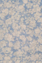 Close-up of light, semi-transparent fabric with a motif floral in white on a pale bleu ciel background. The flowers and leaves are softly outlined, creating a delicate and airy appearance reminiscent of an élégante étole lin.