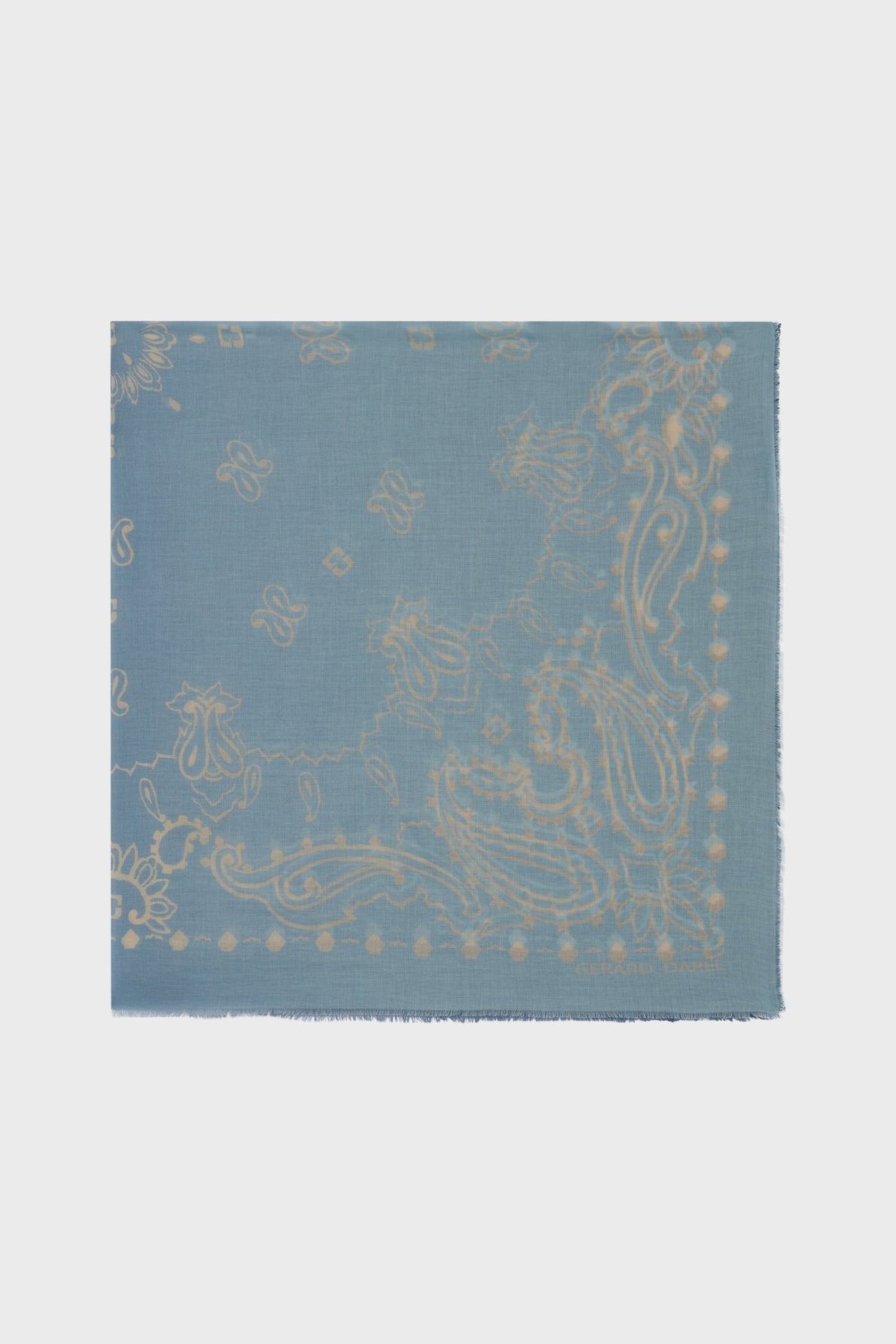 Light blue carré bandana scarf crafted from soft coton, featuring a subtle beige paisley and floral pattern. The edges are slightly frayed, while small motif géométrique accents and ornamental details are delicately scattered throughout the design.