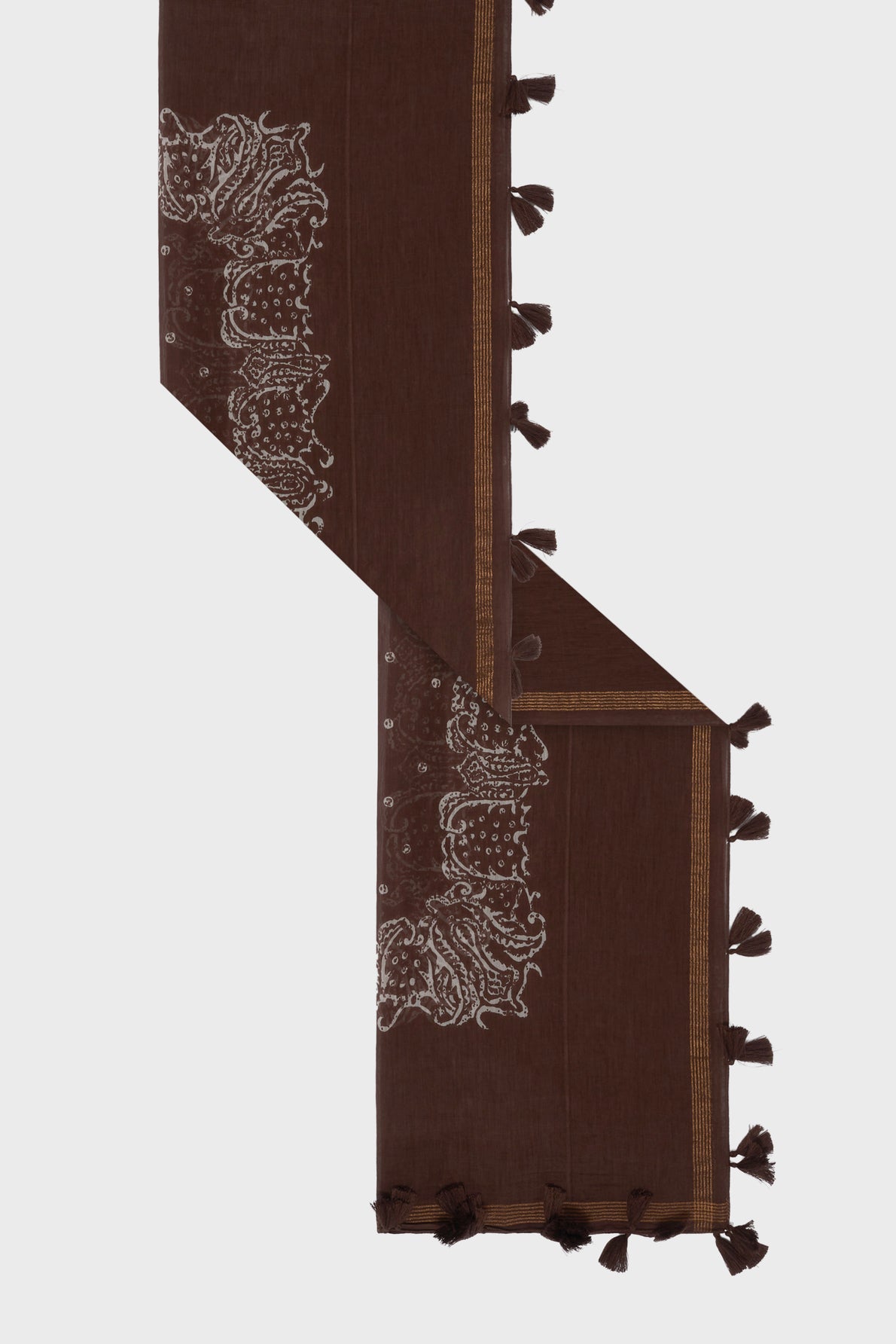Brown woven scarf with white intricate motif ethnique patterns at one end, golden border lines, and small tassels along the edges, displayed on a light background in a zigzag layout.