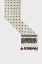A cream-colored textile crafted from coton et soie, adorned with a brown dotted pattern, a floral embroidered border reminiscent of an élégante étole florale, and finished with brown tassels along one edge, set against a plain white background.
