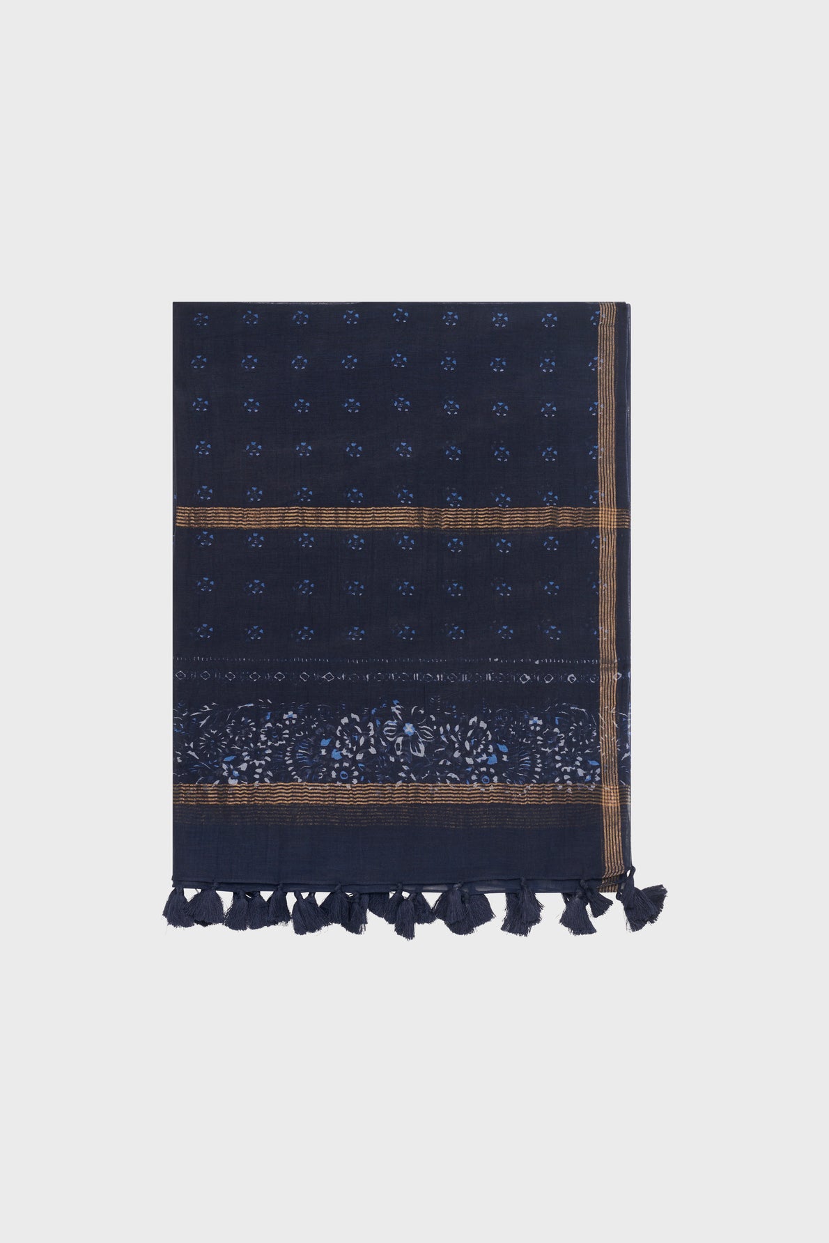 A folded dark blue patterned scarf, known as the étole Daphné, with small imprimé floral designs, thin brown stripes, and tasseled edges, displayed on a light gray background.