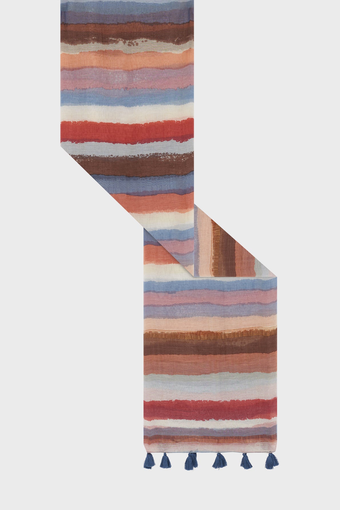 A colorful étole rayée with horizontal stripes in shades of brown, blue, pink, and red, featuring blue tassels along one edge. This vibrant écharpe coton soie is displayed diagonally on a plain light background.