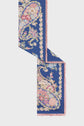 A blue carré en soie with a large paisley floral pattern in pink, cream, and green, bordered by small motif floral accents and trimmed with soft pink edges.