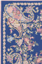 A blue fabric with intricate paisley and motif floral patterns in cream, pink, red, and light blue, bordered with a fringe on the left edge—a perfect choice for a carré en soie.