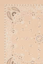 A close-up of a light peach foulard coton featuring a classic white and dark brown imprimé bandana with paisley and floral patterns along the edges and center.
