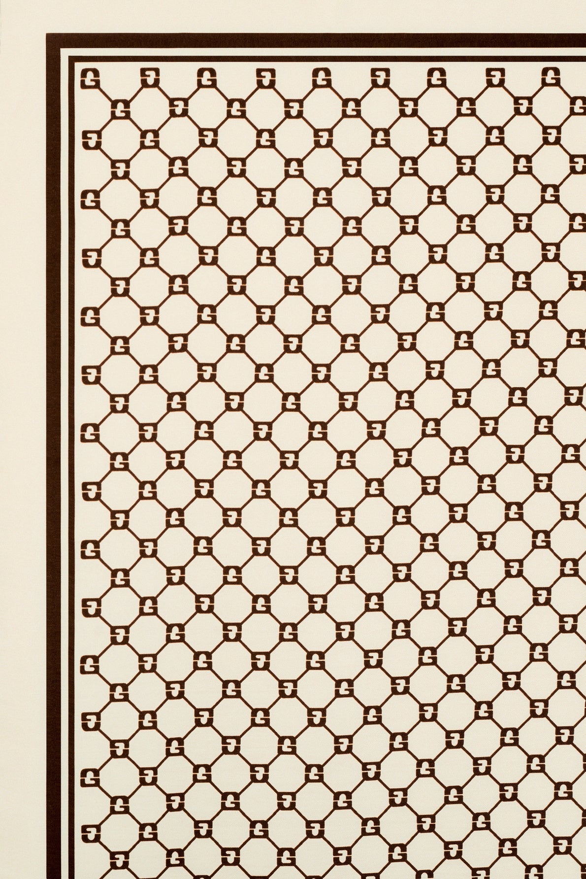 A geometric pattern of hexagons interconnected by short lines, creating a honeycomb effect, with a dark brown design on a cream-colored background and bordered by two brown lines. This élégant carré soie is highlighted by the subtle integration of the monogramme GD, making it an édition limitée accessory that combines timeless style with refined detail.