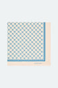 A square silk scarf, or carré soie, with a white background and blue geometric pattern, bordered by a striking blue stripe. The brand name GERARD DAREL and the distinctive monogramme GD are printed in blue in one corner, making this piece a refined accessoire cheveux or the perfect addition to your ensemble.