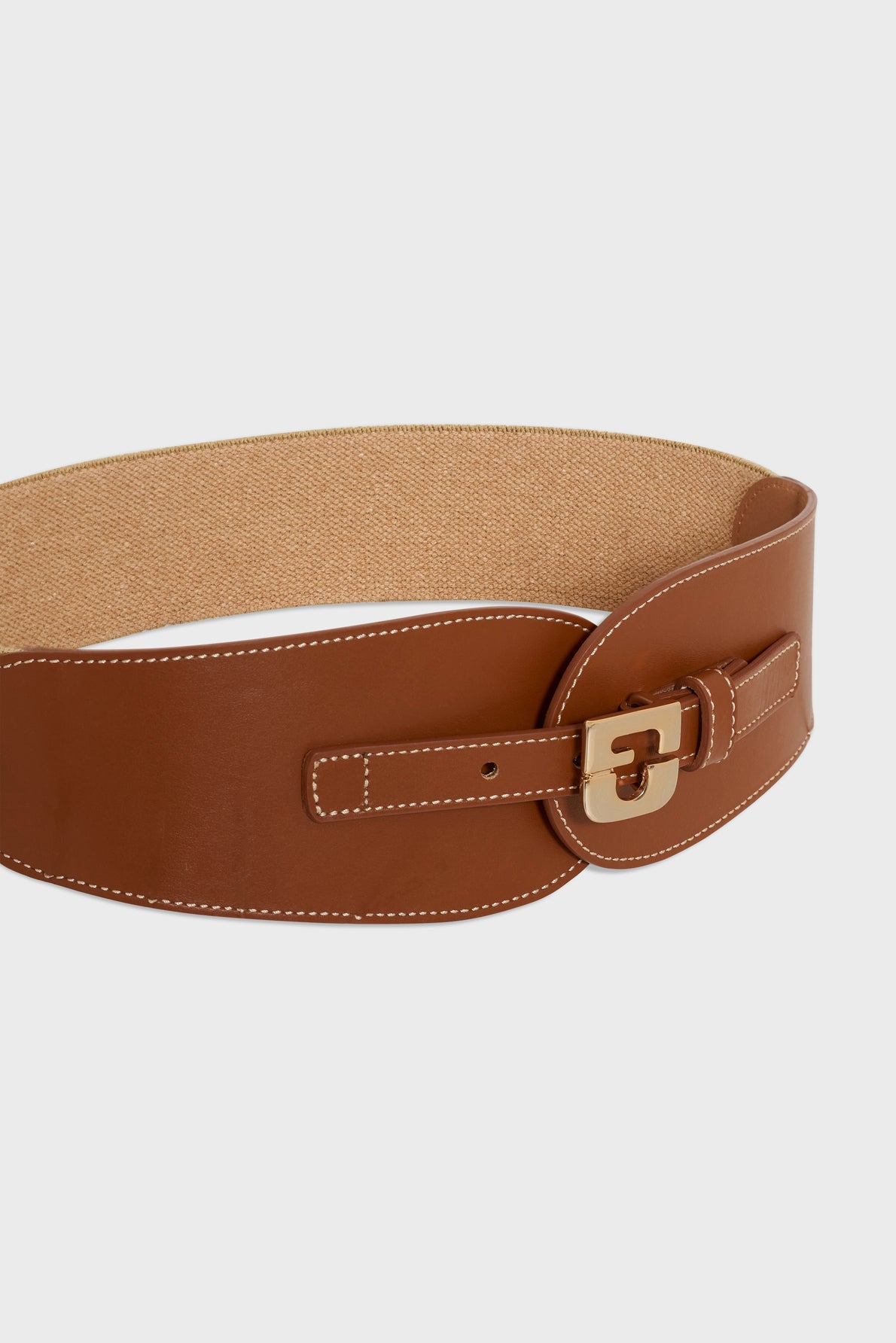 A wide brown leather ceinture Olympe belt with white stitching, a gold rectangular buckle, and an elastic beige back section, displayed on a plain light background. This stylish accessory by Gerard Darel beautifully echoes the timeless elegance of a ceinture corset design.
