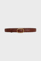 Brown leather belt with small perforated holes and a gold oval buckle, displayed against a plain white background—a ceinture élégante that blends timeless style with modernity.