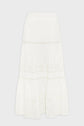 White, midi-length skirt with an elastic waistband, featuring eyelet embroidery in floral and circular patterns and tiered sections with lace trim. Skirt is displayed against a plain white background.