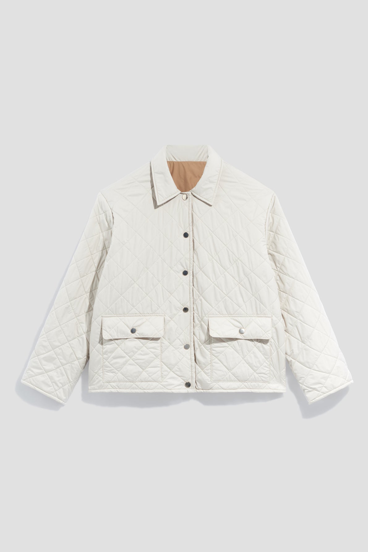 A white, quilted jacket perfect as a veste mi-saison, featuring snap buttons, a pointed collar, long sleeves, and two front flap pockets, displayed on a light gray background.