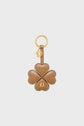 Brown leather porte-clé trèfle in the shape of a four-leaf clover with white stitching, gold keyring, and a small gold charm featuring a logo. This elegant porte-clé cuir is both stylish and practical, adding a touch of luck to your everyday essentials.