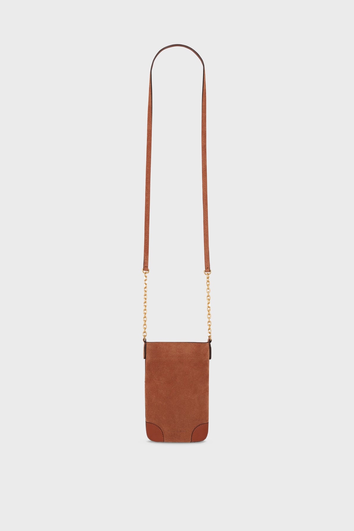 Brown suede crossbody bag with a long strap and small gold chain details. This elegant cuir velours accessory features a rectangular shape with rounded leather corners, a minimal design, and practical bandoulière chaîne—perfect as a chic porte-téléphone. Displayed against a plain white background.