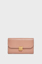 A pink leather wallet from Gerard Darel, featuring a gold clasp, sits centered on a plain white background—an accessoire élégant that exudes timeless style.