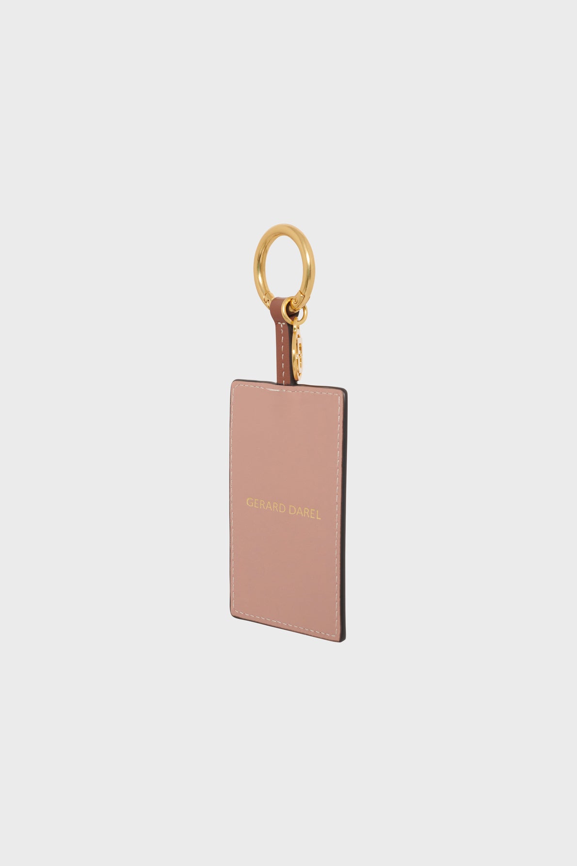 A rectangular blush pink porte-clé cuir with gold hardware and GERARD DAREL embossed in gold on the front, photographed against a plain white background.