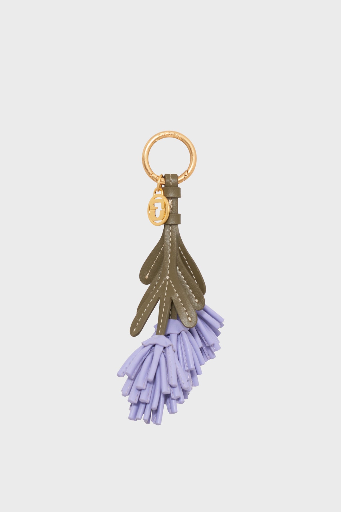 A charming porte-clés Provence featuring a gold ring, olive green leather leaf shapes, and a delicate cluster of light purple tassels reminiscent of fragrant lavender fields hanging at the bottom.