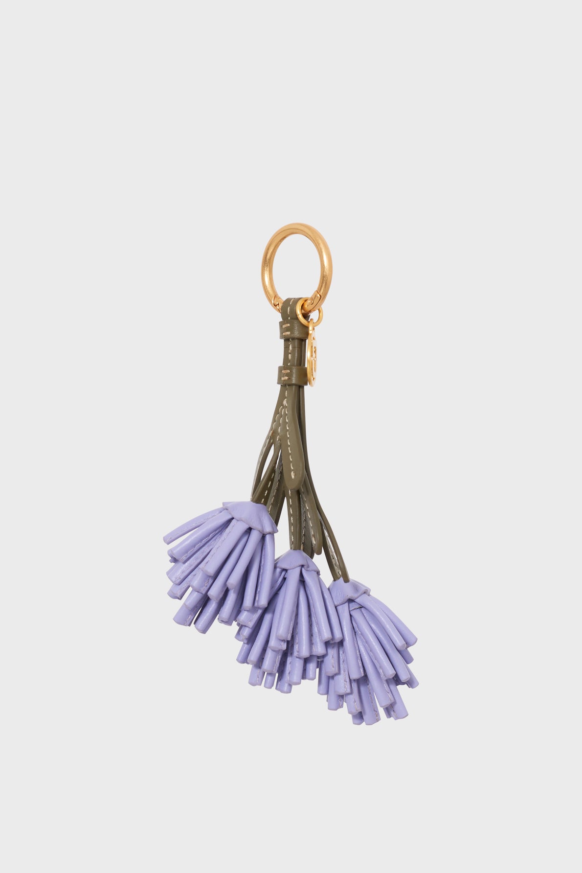 A stylish porte-clés cuir with a gold ring and green straps, holding three clusters of purple leather tassels reminiscent of porte-clés lavande, set against a plain white background.