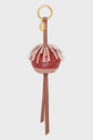 A decorative porte-clé en cuir with a gold ring, featuring layered pink and red leather strips forming a spherical shape, and two long brown leather tassels hanging down—an elegant accessoire sac for your favorite handbag.