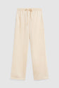 Beige satin pajama pants (pantalon satiné) with an elastic waistband (taille élastiquée) and drawstring, laid flat on a light gray background. The pants have straight legs and a relaxed fit.