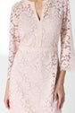 A woman wearing a light pink robe dentelle with three-quarter sleeves and a V-neckline; only her torso and right arm are visible.