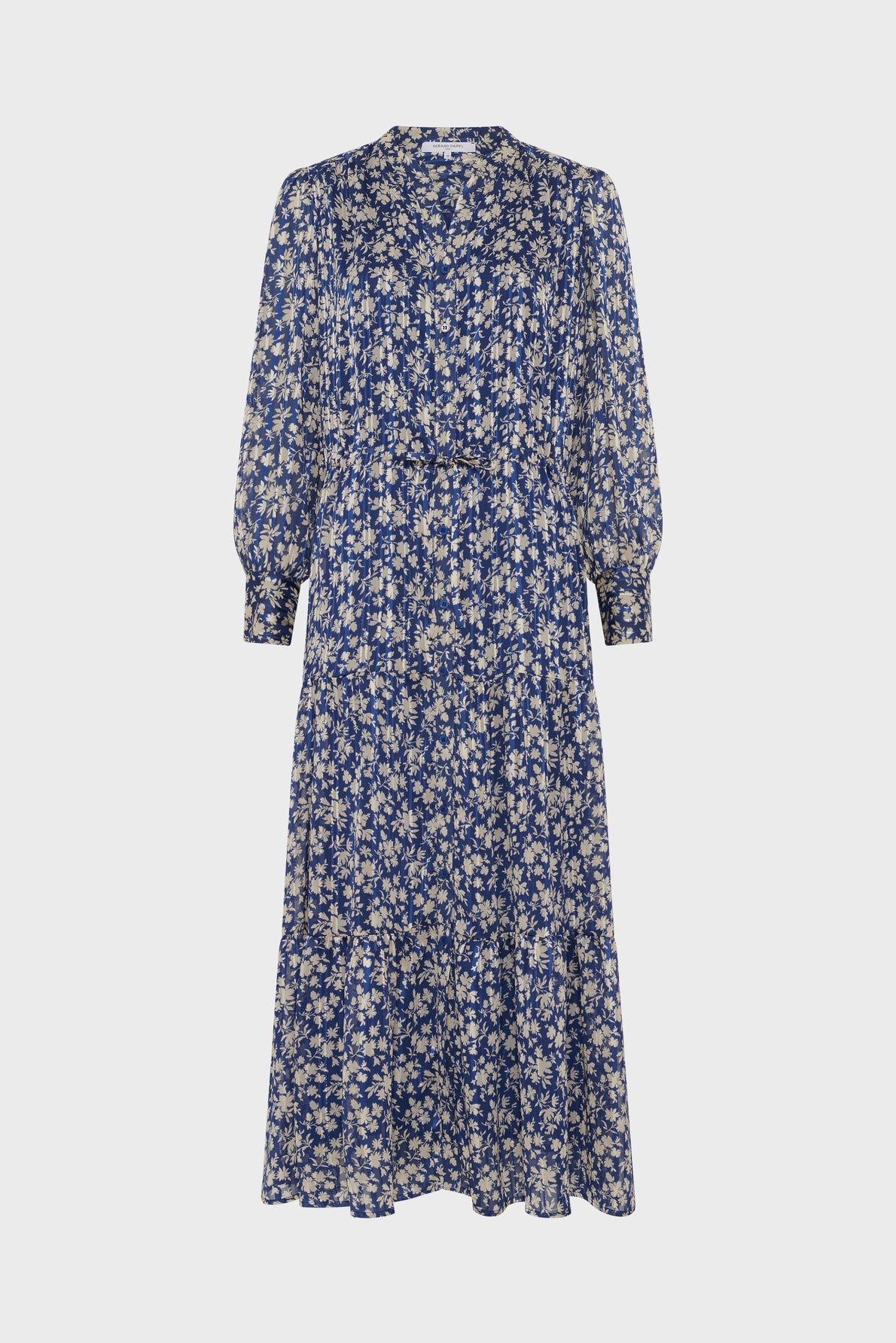A long-sleeved, midi-length dress with a blue background and white floral print, featuring a V-neckline and a loose, flowing silhouette.