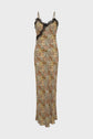 Floral print slip dress with thin straps, black lace trim (dentelle) along the neckline, and a fitted silhouette. The dress features a motif floral in a mix of muted colors and reaches down to the ankles, creating an elegant robe longue effect. The background is plain white.