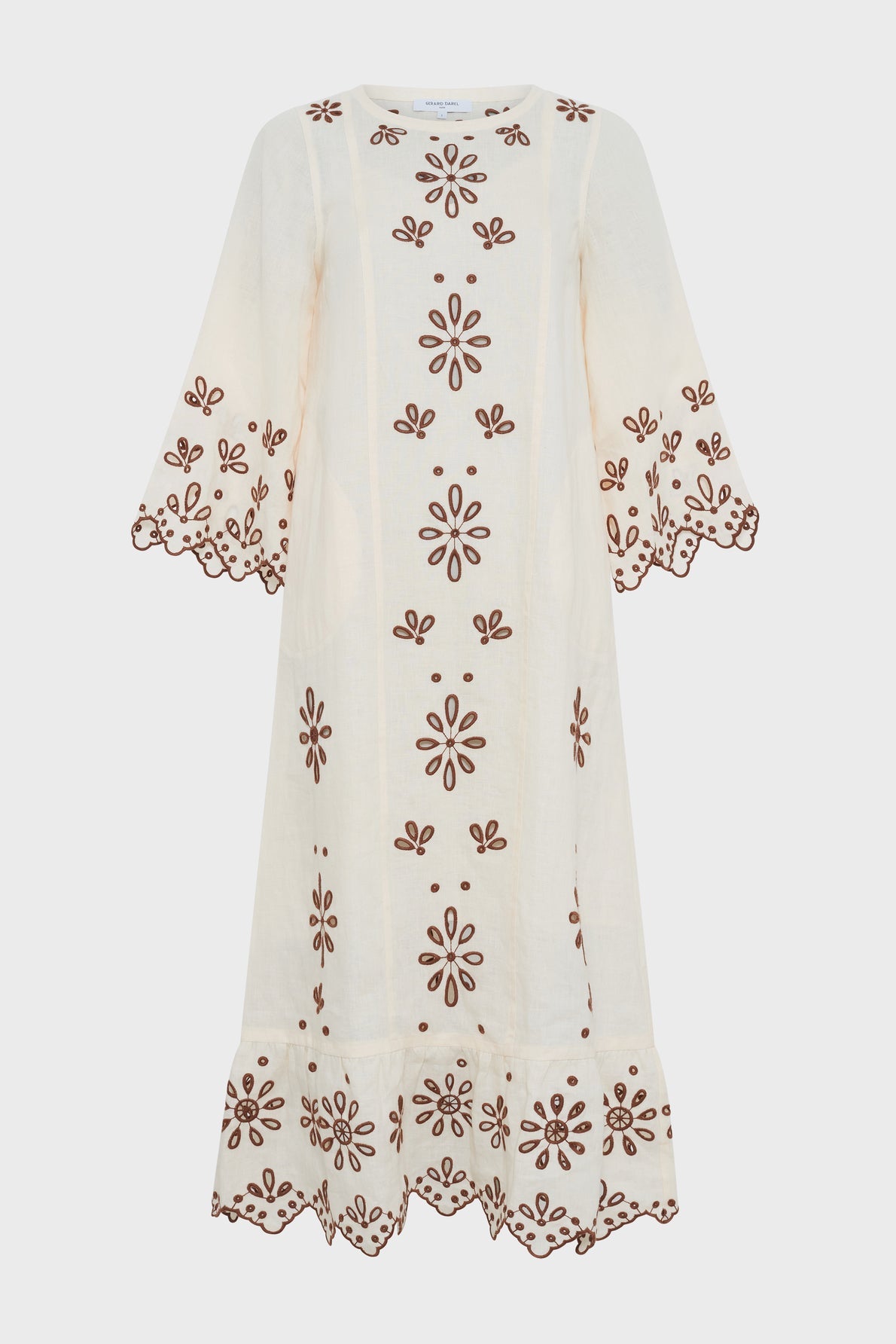 Cream-colored knee-length dress with brown broderies florales, this piece features scalloped edges on the sleeves and hem. Designed with wide, three-quarter sleeves and a relaxed, flowy fit, it effortlessly channels a look bohème against a plain white background.