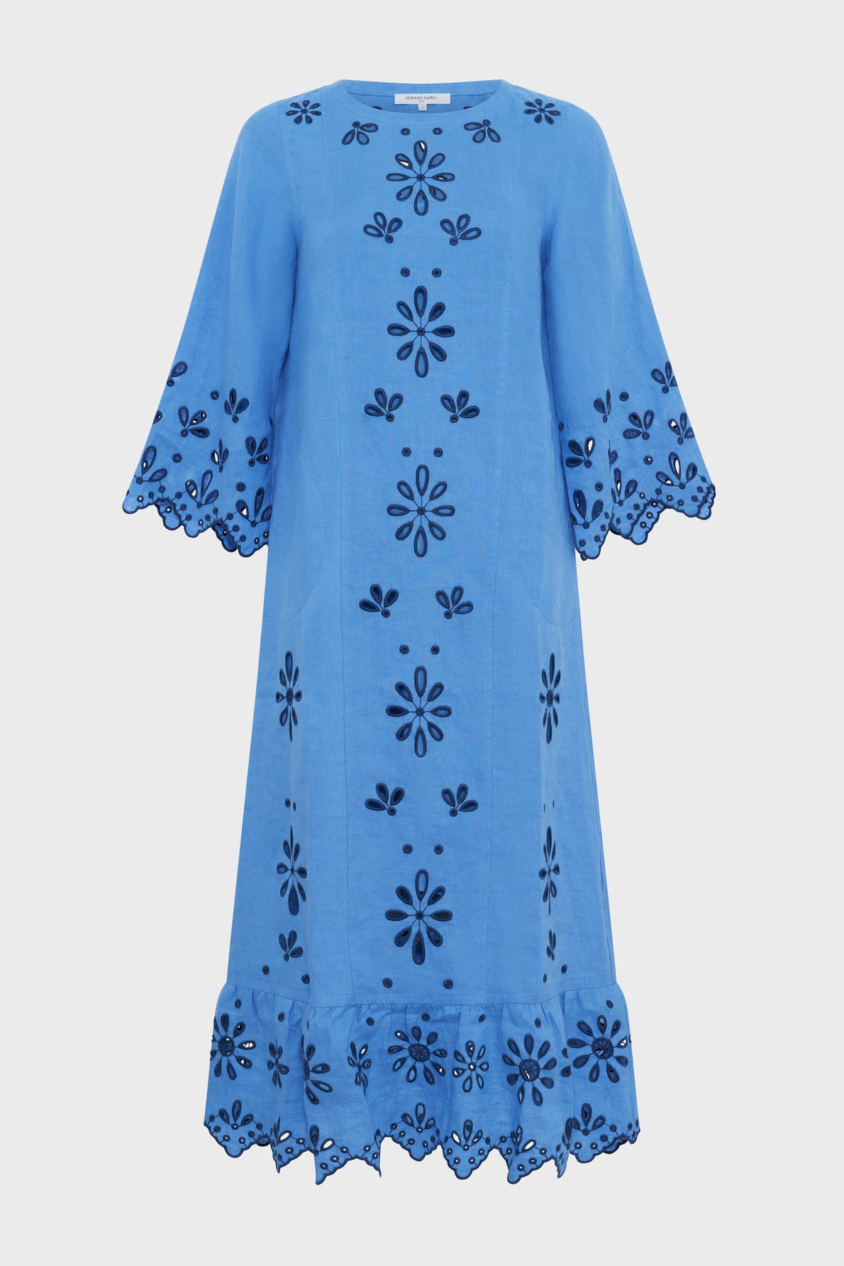 A blue knee-length dress with wide sleeves, floral cutout embroidery, and scalloped edges on the sleeves and hem. The dress has a loose, relaxed fit and features a symmetrical flower pattern that beautifully captures a look bohème with its intricate broderies florales.