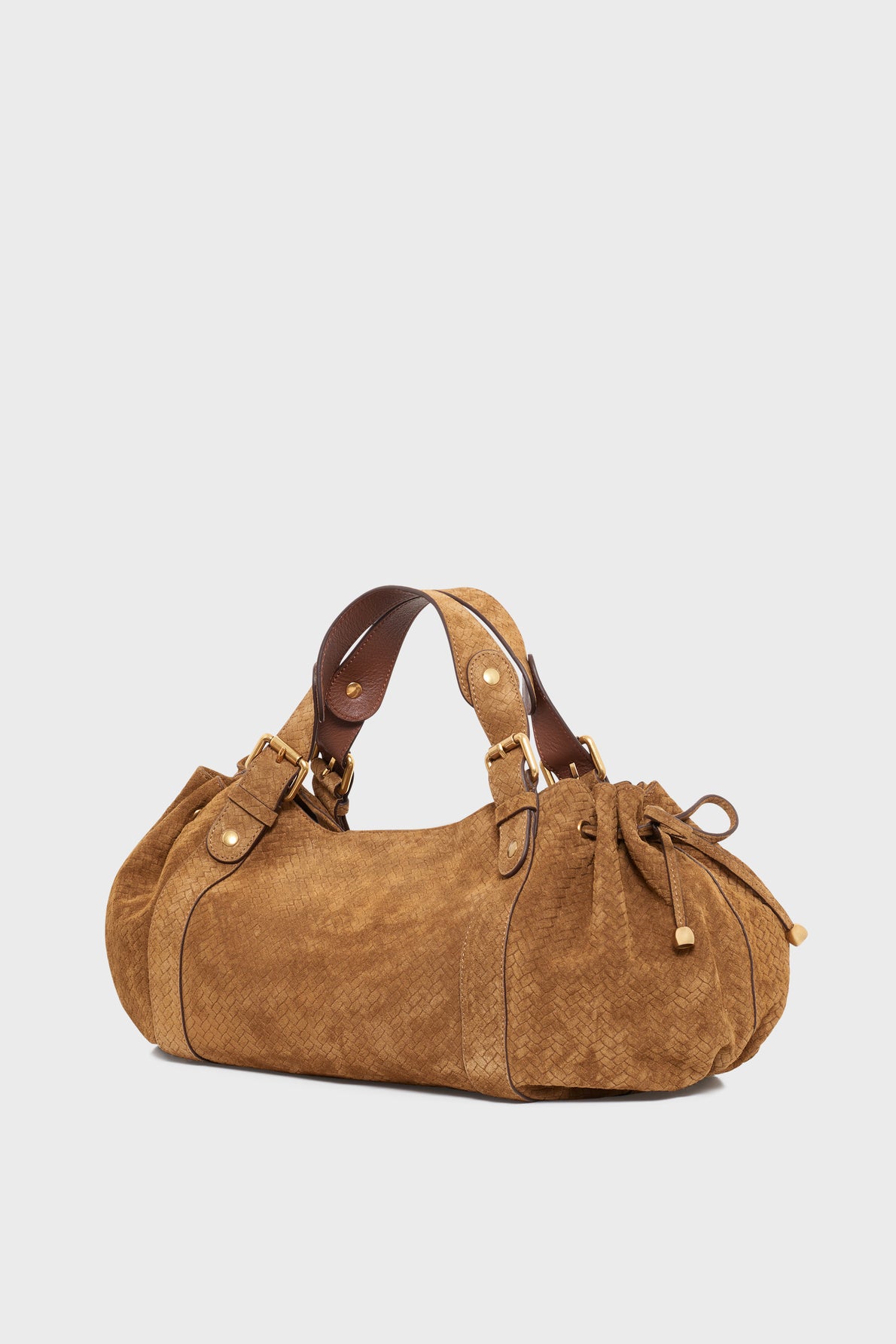 Brown suede handbag with short handles, gold-tone hardware, and a decorative side bow. Crafted in a soft cuir velours tressé with visible stitching details, this sac à main features a rounded shape that gives it a casual yet stylish appearance.