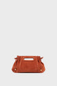 A rust-colored sac à main in cuir velours features a rectangular cutout handle and gold-tipped drawstring details, set against a plain light background for an élégant finish.