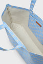 Open blue cabas élégant with a beige interior, showing a small inner pocket and light brown geometric pattern on the exterior and straps.