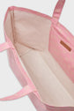 Open pink cabas en toile tote bag with a beige interior, two handles, and a geometric pattern on the outer walls. A small rectangular label is attached to the inner side near the top. This stylish cabas monogrammé sac LOLITA sits on a neutral background.