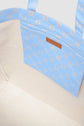 Open cabas en toile tote bag with a cream fabric interior and a blue patterned pocket attached inside, featuring tan logo accents and brand label.