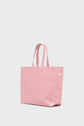 A large, light pink cabas en toile with two handles and a subtle repeating pattern, this elegant sac porté épaule is displayed against a plain white background.