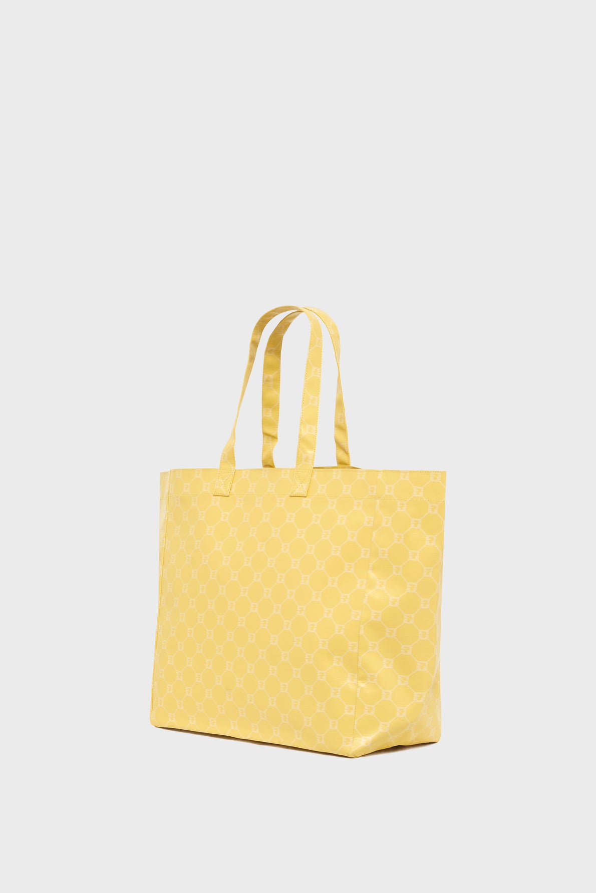 A yellow cabas monogrammé with light-colored geometric patterns, featuring two handles, is shown against a plain, light background.