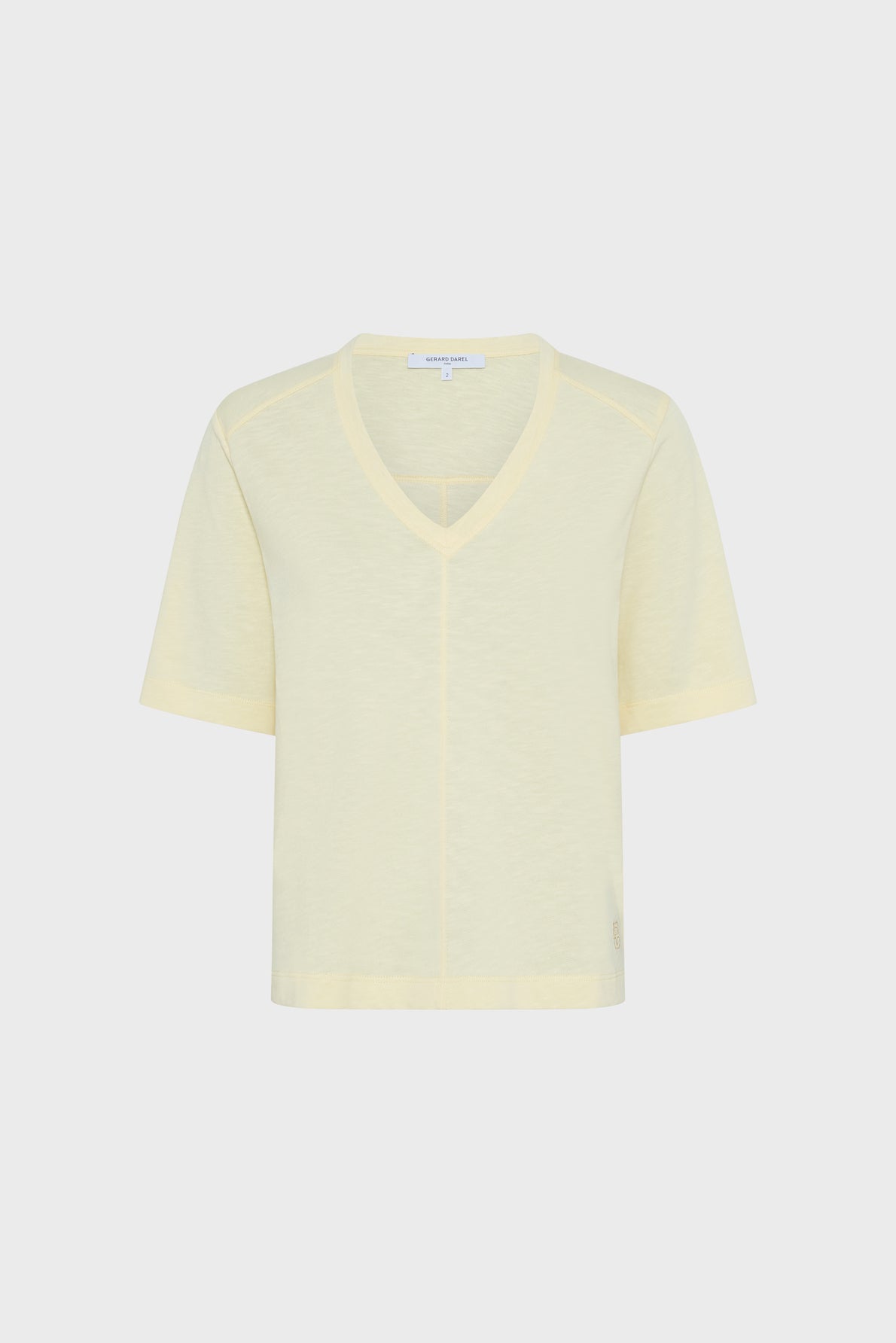 A light yellow, short-sleeve V-neck t-shirt is displayed against a plain white background. The shirt has a relaxed fit and minimal detailing.