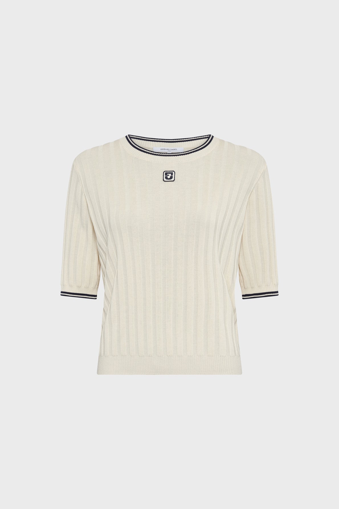 A cream-colored, short-sleeve ribbed knit sweater with black trim on the collar and cuffs, and a small black-and-white square logo on the chest.