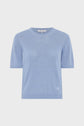 Light blue short-sleeve knit sweater with a crew neckline, ribbed cuffs and hem, and a small stitched logo near the bottom left. The sweater is displayed on a plain white background.