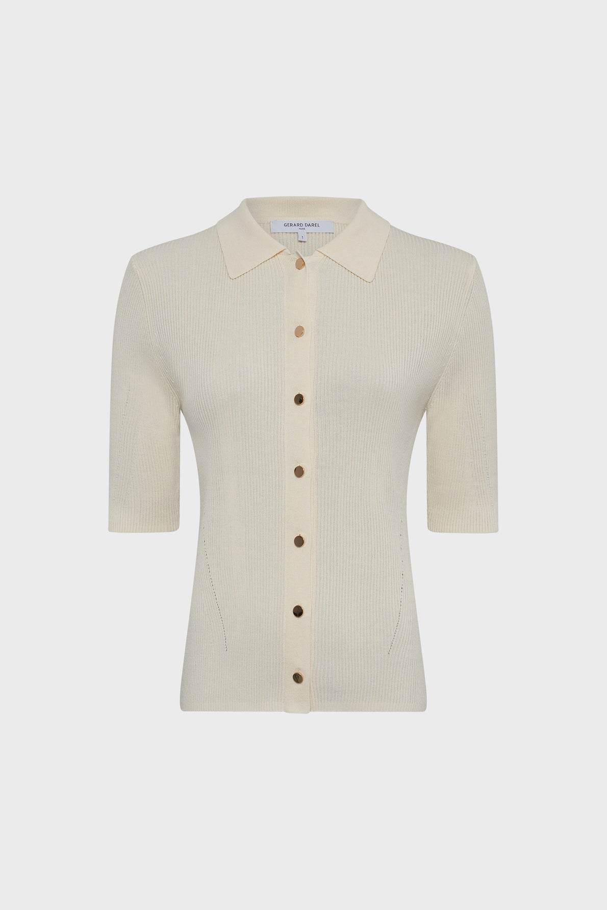 Cream-colored, short-sleeved gilet polo in maille côtelée with a collar and front button closure. The buttons are evenly spaced and brown, adding a classic touch, while the cardigan features a fitted silhouette.