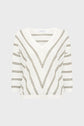 White knit sweater with brown and beige diagonal and horizontal stripes, featuring a V-neck and three-quarter length sleeves, displayed on a plain light gray background. This pull rayé femme, known as the pull Lerya, effortlessly combines style and comfort.