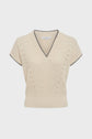 Beige short-sleeve knitted sweater with a col V, ribbed hem and cuffs, and black trim along the collar and sleeve edges. This maille écrue features subtle vertical knit details on the front for an elegant finish.