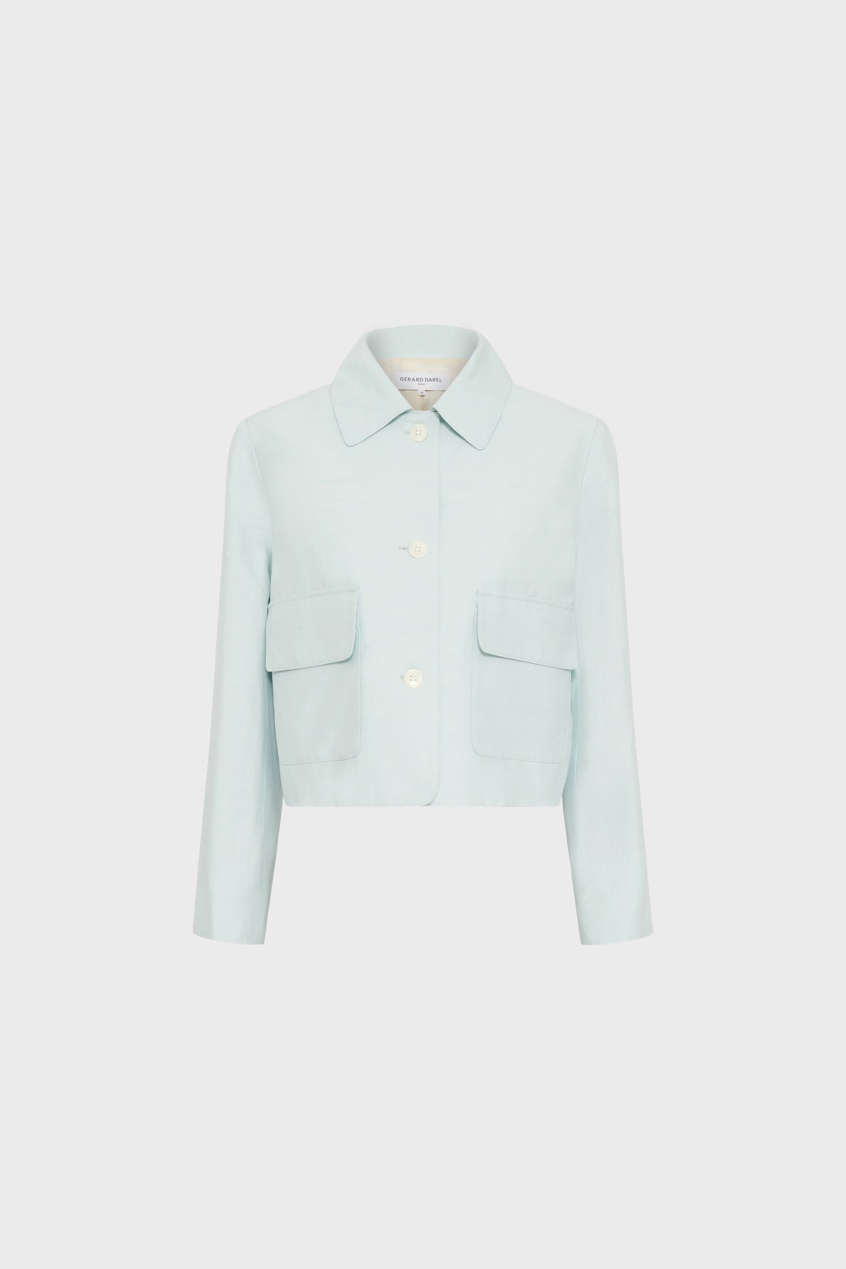 Light blue, long-sleeve, veste courte with a col chemise, large white buttons, and two front flap pockets, displayed on a plain white background.