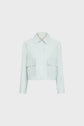 Light blue, long-sleeve, veste courte with a col chemise, large white buttons, and two front flap pockets, displayed on a plain white background.