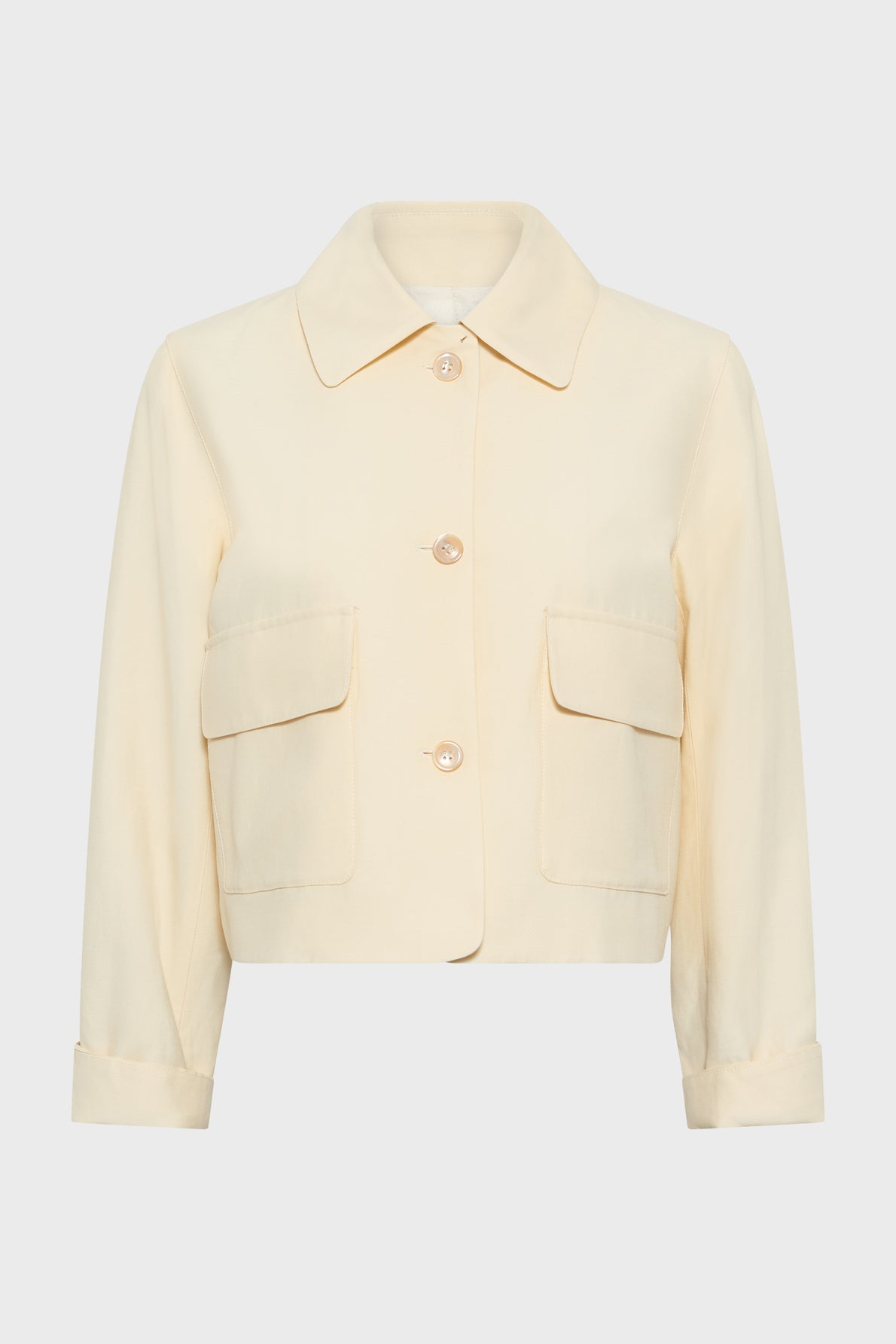Cream-colored, long-sleeve, button-up veste courte with a collar and two large front pockets, displayed on a plain white background.
