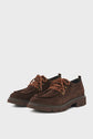 Pair of brown derby cuir velours lace-up shoes (chaussure lacée) with thick, rugged semelle crantée soles and brown-and-orange laces, displayed on a plain light background.