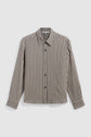 A long-sleeve button-up chemise à rayures with vertical black and beige stripes, a pointed collar, and buttoned cuffs, laid flat against a plain white background. Crafted from une matière fluide, this shirt features an elegant motif rayé that adds a sophisticated touch to any wardrobe.