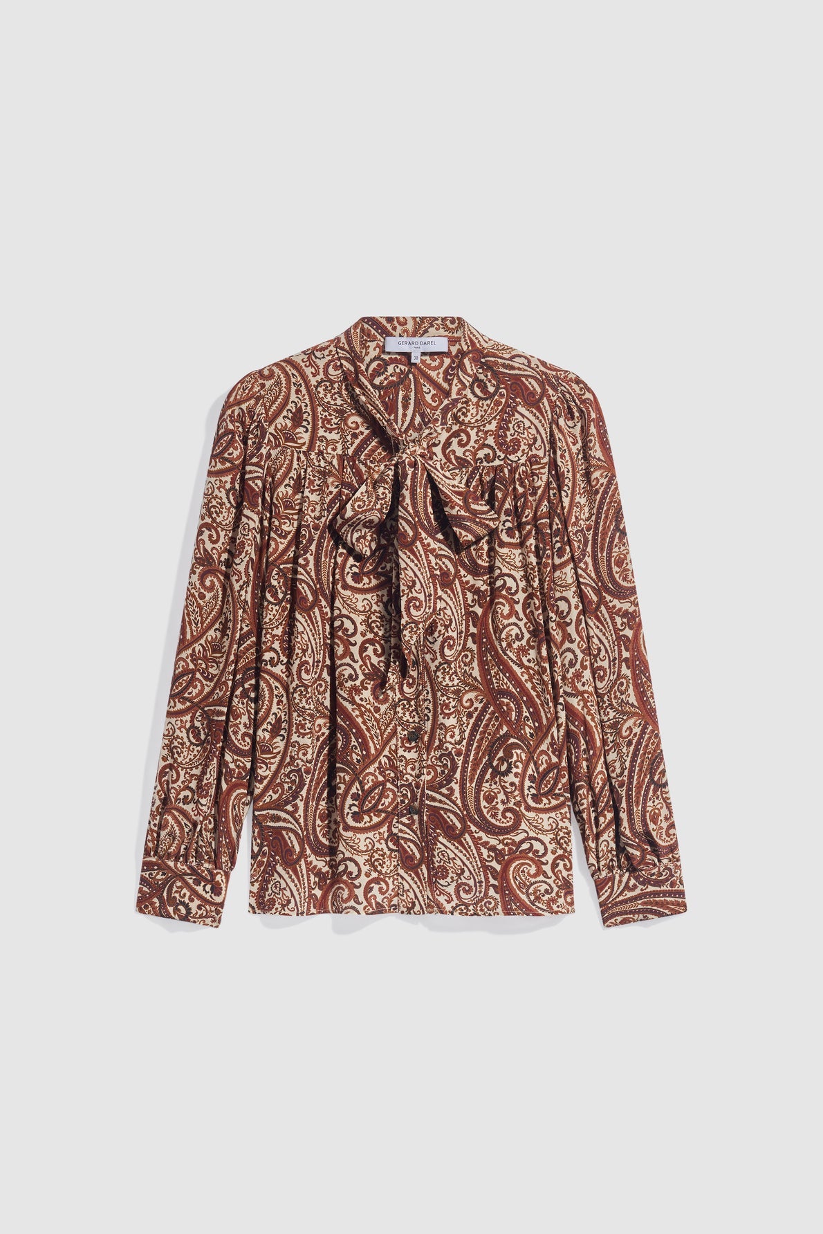 A long-sleeve chemise cachemire with a brown and beige paisley pattern, featuring a col lavallière bow tie at the neck and gathered details on the shoulders, crafted from soft viscose haboutaï for an elegant drape.