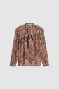 A long-sleeve chemise cachemire with a brown and beige paisley pattern, featuring a col lavallière bow tie at the neck and gathered details on the shoulders, crafted from soft viscose haboutaï for an elegant drape.