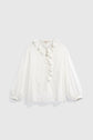 A white long-sleeve chemise coton blanc with a ruffled collar, pleated front, button closure, and loose sleeves with gathered cuffs, this elegant piece features delicate volants at the neckline for a subtle touch of style bohème chic. Displayed on a plain light background.