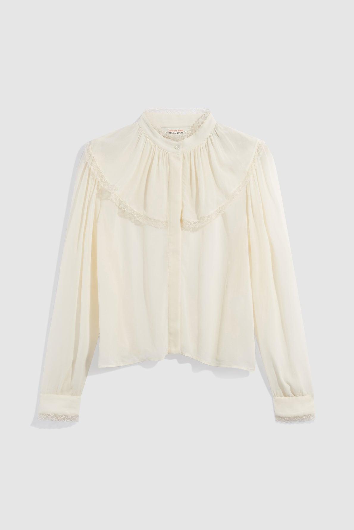A long-sleeve, off-white chemise en crêpe with lace trim on the cuffs and a delicate col volanté, featuring a round yoke, manches bouffantes, and a loose fit.